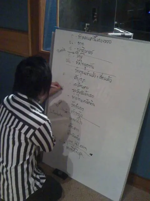 deeboyd-natty Natty กำลังเขียนคิวเพลง วิธีต่อเพลง และคีย์เพลงลงบน whiteboard ให้นักดนตรีดูระหว่างซ้อม